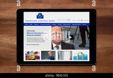 The website of European Central Bank is seen on an iPad tablet, which is resting on a wooden table (Editorial use only). Stock Photo