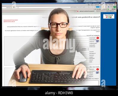 Young woman sitting at a computer surfing the Internet, sending an online complaint on a page of the online NRW Police station Stock Photo