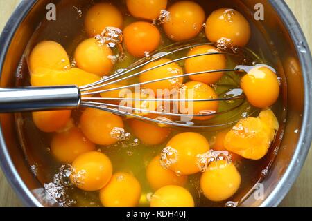 Egg yolks and egg white, raw cracked chicken eggs in a bowl Stock Photo