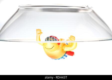 Wind-up toy figure of a boy swimming in a fish bowl, illustration Stock Photo