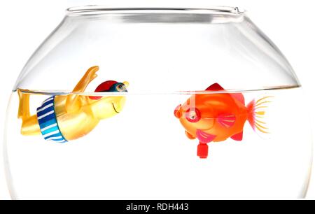 Wind-up toy figure of a boy swimming with a toy fish in a fish bowl, illustration Stock Photo