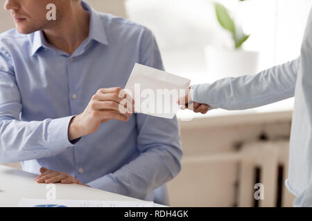 Close up businessman taking envelope with bribe from woman Stock Photo