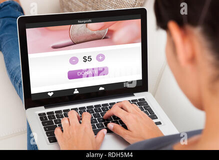 Close-up Of A Woman's Hand Using Laptop To Donate Money Stock Photo