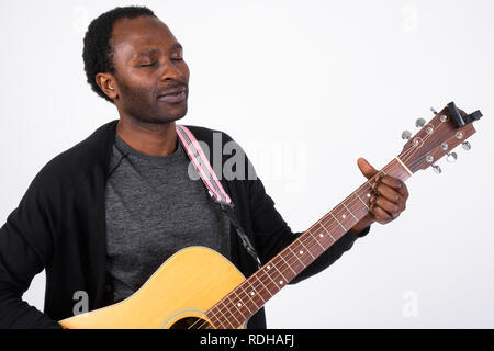 Handsome African man looking relaxed while playing guitar Stock Photo