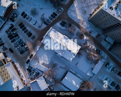 Aerial city view with crossroads, roads, houses, buildings, parks, parking lots, bridges in winter day,  there is a lot of snow around Stock Photo