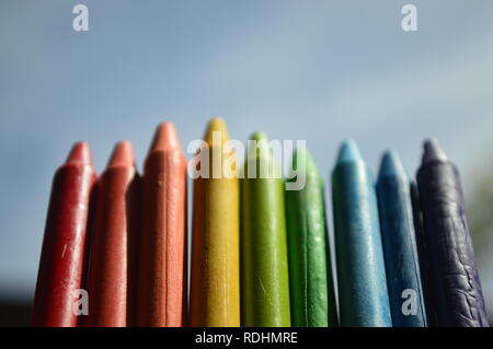 Colorful crayons lined up in the clear blue sky Stock Photo