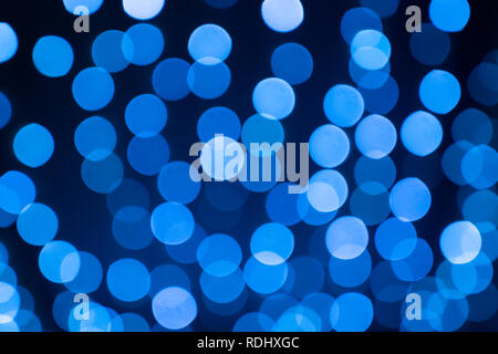 Abstract festive blue bokeh out of focus balls on black background Stock Photo