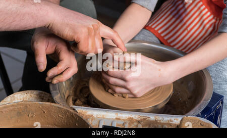 Teaching pottery to children. The teacher gives a master class in modeling Stock Photo