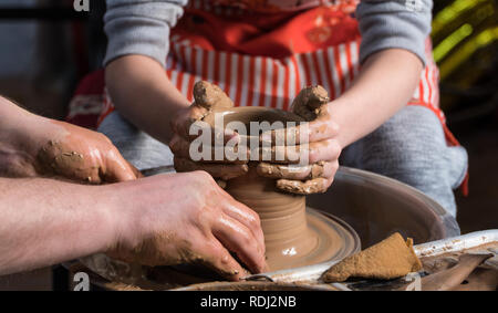 Teaching pottery to children. The teacher gives a master class in modeling Stock Photo