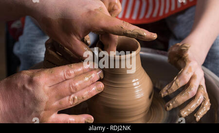 Teaching pottery to children. The teacher gives a master class in modeling Stock Photo