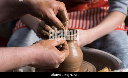 Teaching pottery to children. The teacher gives a master class in modeling Stock Photo