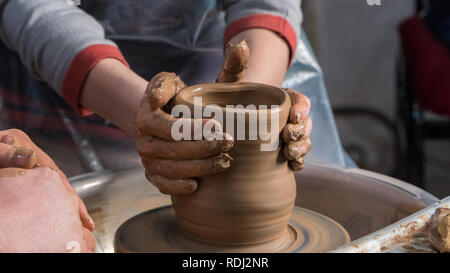 Teaching pottery to children. The teacher gives a master class in modeling Stock Photo