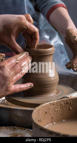 Teaching pottery to children. The teacher gives a master class in modeling Stock Photo