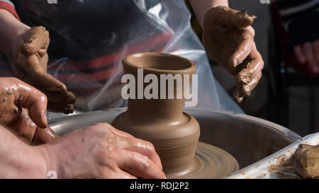 Teaching pottery to children. The teacher gives a master class in modeling Stock Photo