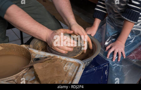 Teaching pottery to children. The teacher gives a master class in modeling Stock Photo