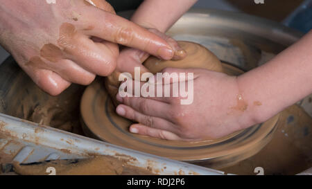 Teaching pottery to children. The teacher gives a master class in modeling Stock Photo