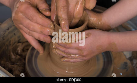 Teaching pottery to children. The teacher gives a master class in modeling Stock Photo