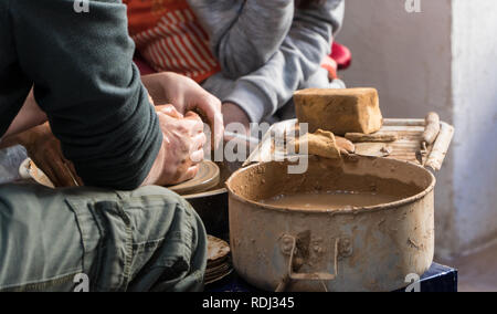 Teaching pottery to children. The teacher gives a master class in modeling Stock Photo