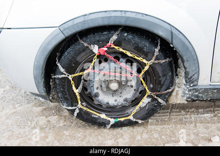 Tire With Mounted Old Snow Chains in the Winter Snowy Day Stock Photo