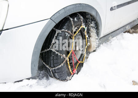 Tire With Mounted Old Snow Chains in the Winter Snowy Day Stock Photo