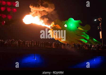 Da Nang, Vietnam - November 11, 2018: the head of the bridge dragon spews smoking fire in the darkness of night in front of the spectators' crowd. Stock Photo