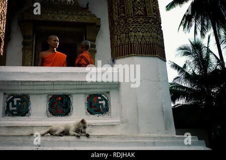 Luang Prabang / Laos - JUL 06 2011: buddhist monks discussing something at the balcony of their monastery decorated with swastika symbols Stock Photo