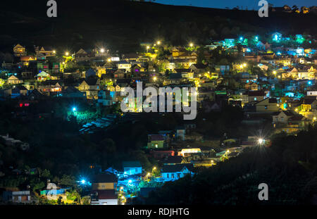 Night scene in the valley with bright houses with colorful lights makes the night scene in the countryside more vibrant in the Da Lat plateau, Vietnam Stock Photo