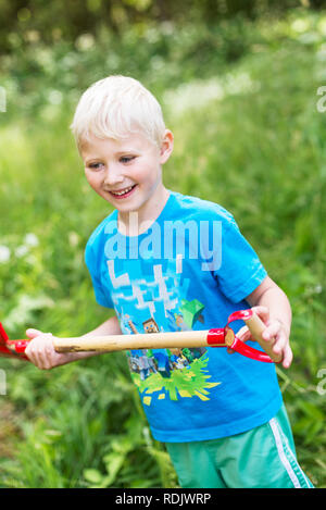 Boy with shovel standing in garden Stock Photo