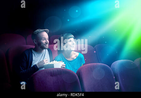 Teenager couple cuddling and watching the climax part of the movie Stock Photo