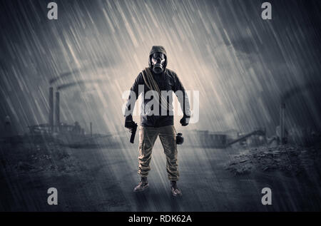 Gas masked survival man coming with arms on his hand  in a demolished dark environment   Stock Photo