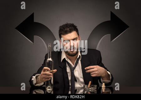 Drunk disappointed man sitting at table with arrows around  Stock Photo