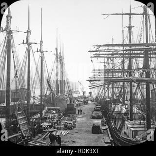 Late Victorian view of the docks in New York City. many sailing ships can be seen loading or unloading their goods. Stock Photo