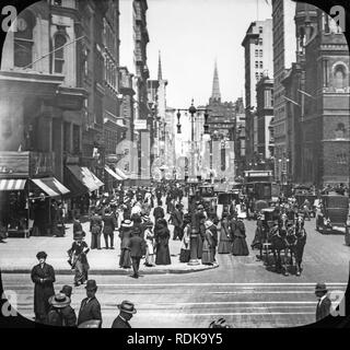 Late Victorian view of New York City. A view looking at 5th Avenue and 42nd Street. Streets are full of people, horse drawn carriage, and very early motor vehicles. Stock Photo