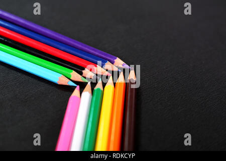Picture of beautiful colored pencils in row. Isolated on the black background. Stock Photo