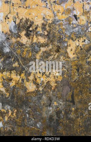 Texture of aged darkened yellow wall of the ancient city of Hoi An, Vietnam. Vertical Stock Photo