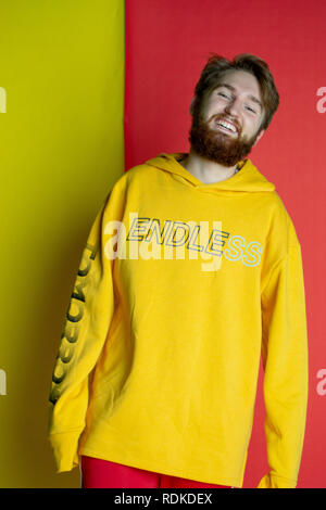 Fashion shot of male posing into the camera wearing clothes that match his backdrop Stock Photo