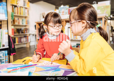 Sisters with Down syndrome coloring pictures in kids library