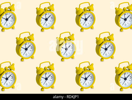 Seamless pattern made of golden analogue clocks in isolated yellow pastel background. Stock Photo