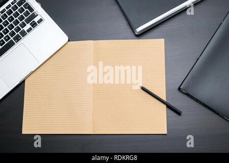 Overhead view of office table with blank notebook and pen, computer keyboard, tablet pc and smartphone. copy space for text, business office workplace Stock Photo