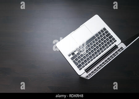A man is working by using a laptop computer on vintage wooden table. Hands typing on a keyboard. Top view, business office workplace Stock Photo