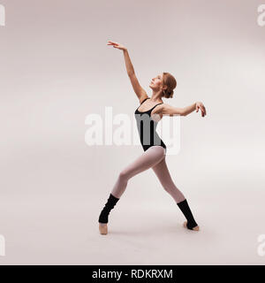 Ballerina in black outfit posing on toes Stock Photo