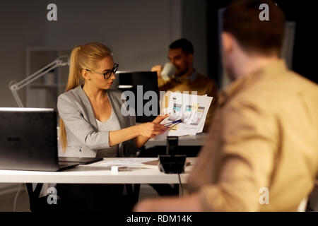 workers with user interface mockup at night office Stock Photo