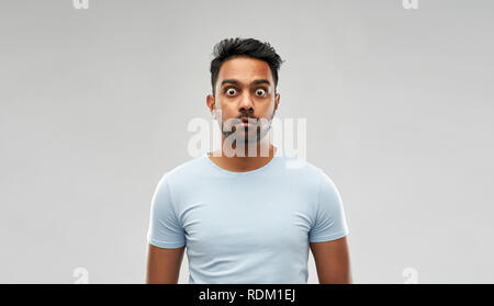 shocked or scared man over grey background Stock Photo