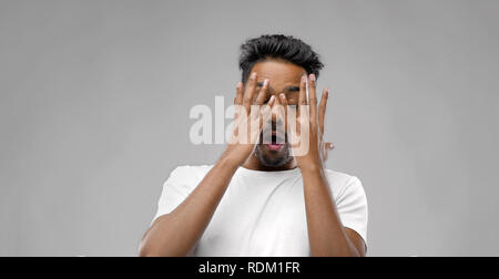 shocked indian man over grey background Stock Photo