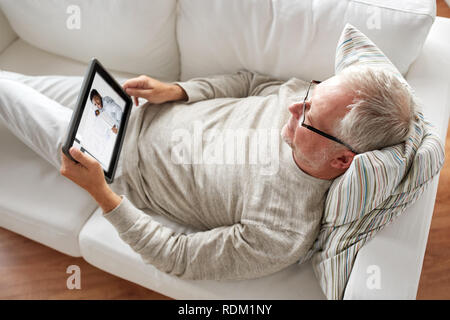 senior man watching webinar on tablet at home Stock Photo