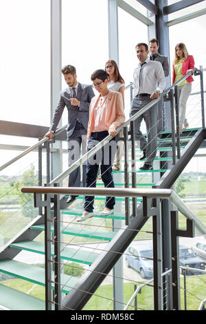 business people walking down stairs in building Stock Photo