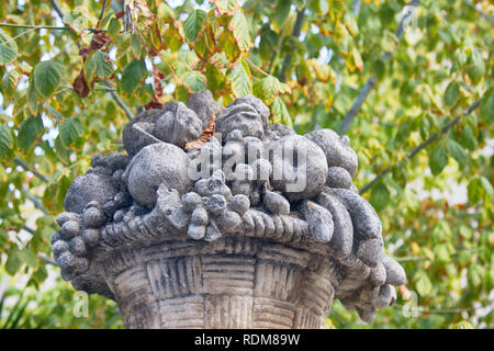 Autumn in Spain. Abundance of sculptural fruits on a heavenly stone dish in the autumn Park, garden sculpture. Motaro Stock Photo