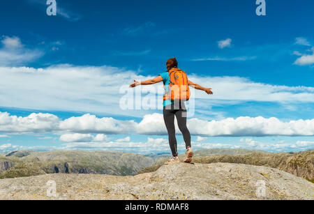 Woman successful hiking silhouette in mountains, motivation and inspiration in beautiful sunset. Female hiker with arms up outstretched on mountain to Stock Photo