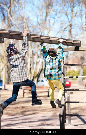 Boys playing on monkey bars Stock Photo