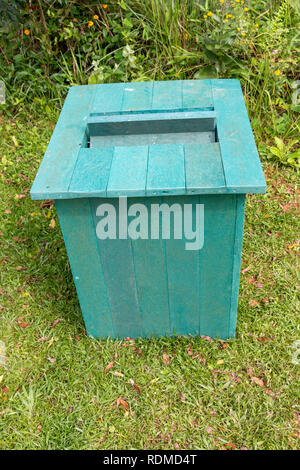 A close up front top view of a green recycled plastic rubbish bin in a outdoor park Stock Photo